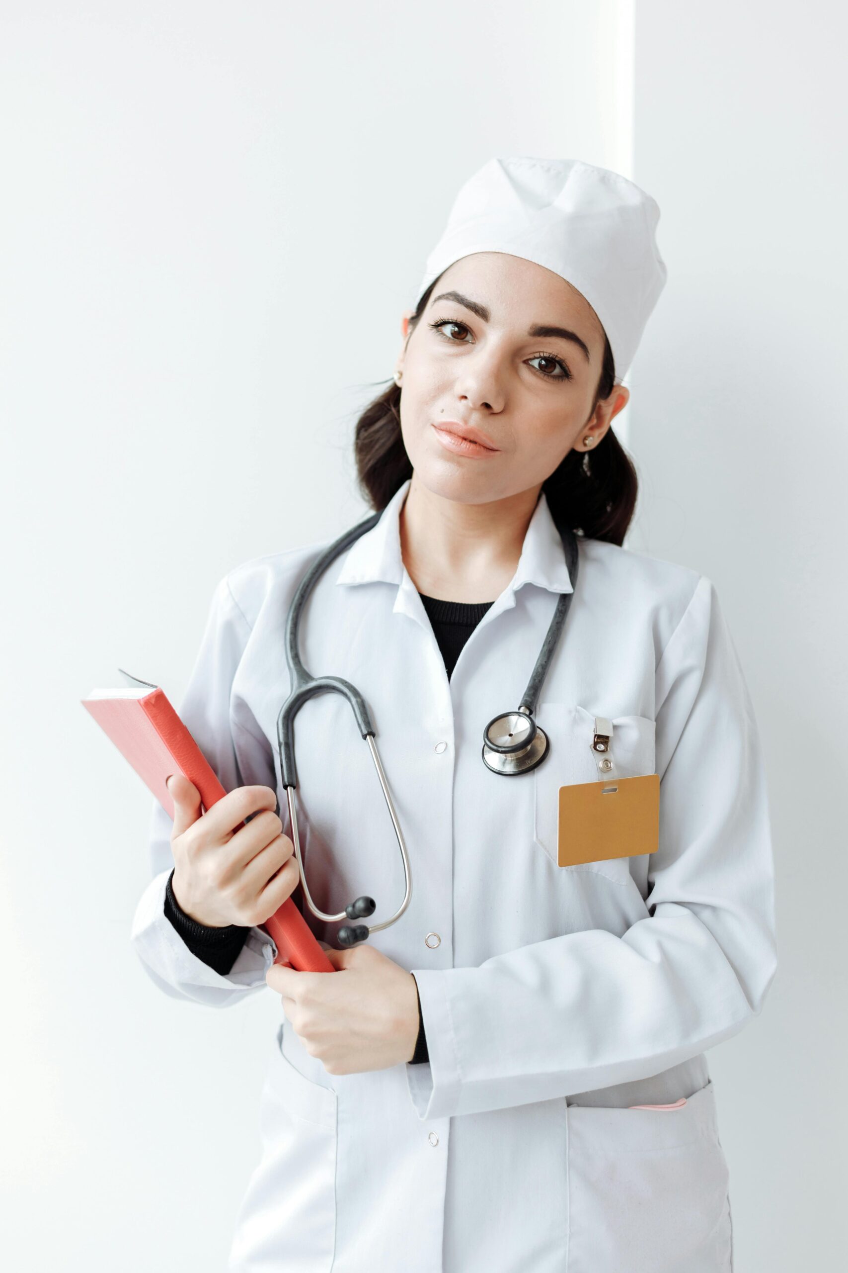 A serious female healthcare professional in uniform with a stethoscope and book.